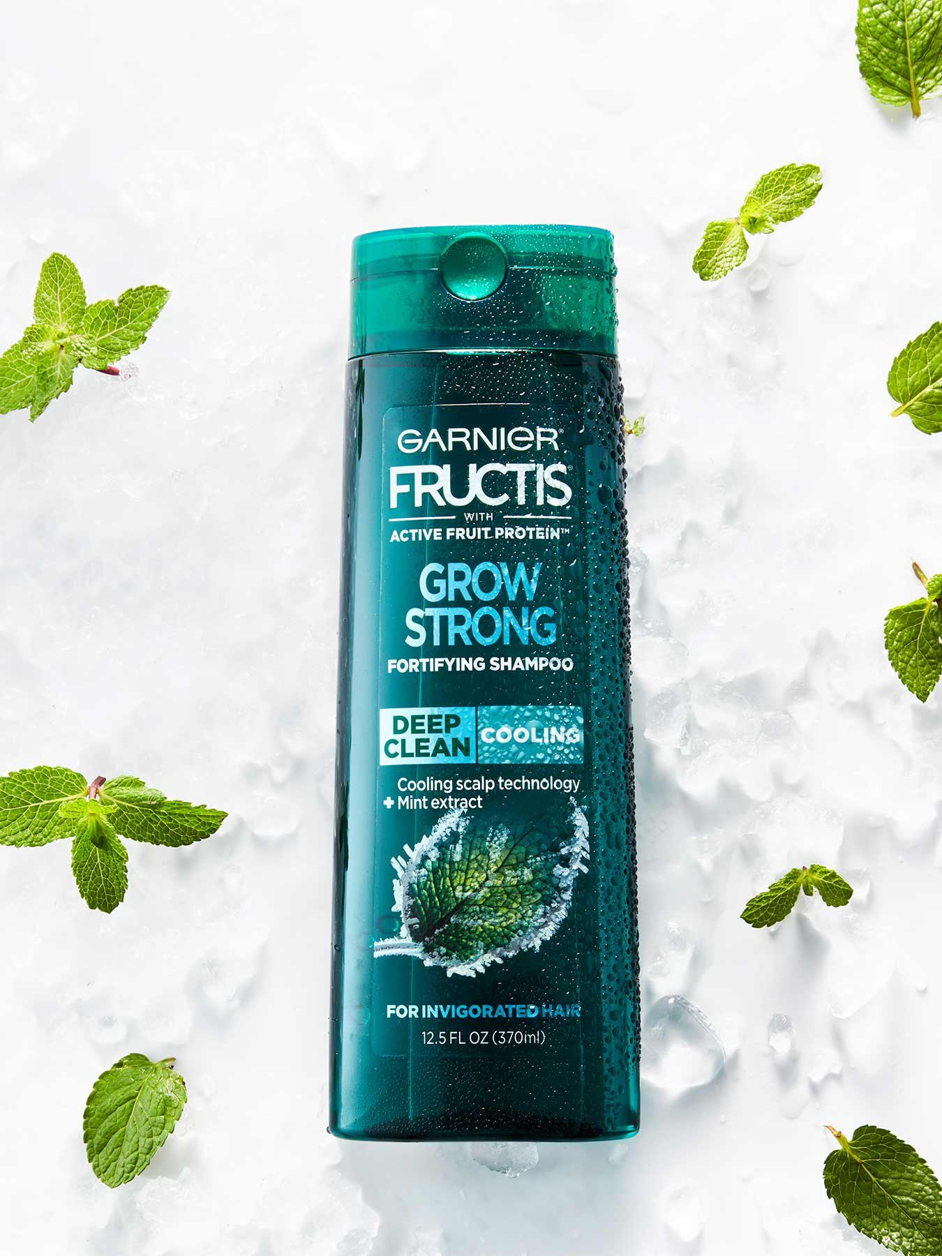 Cooling Deep Clean Shampoo for Men for Invigorated Hair on a bed of ice with mint leaves.
